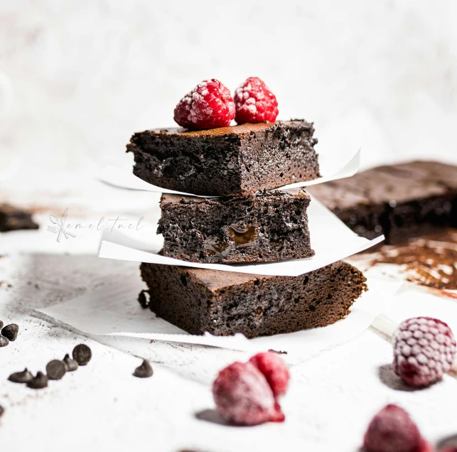 a stack of chocolate bars covered in raspberries