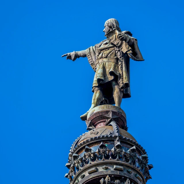 the top of a building that has a tall statue on top