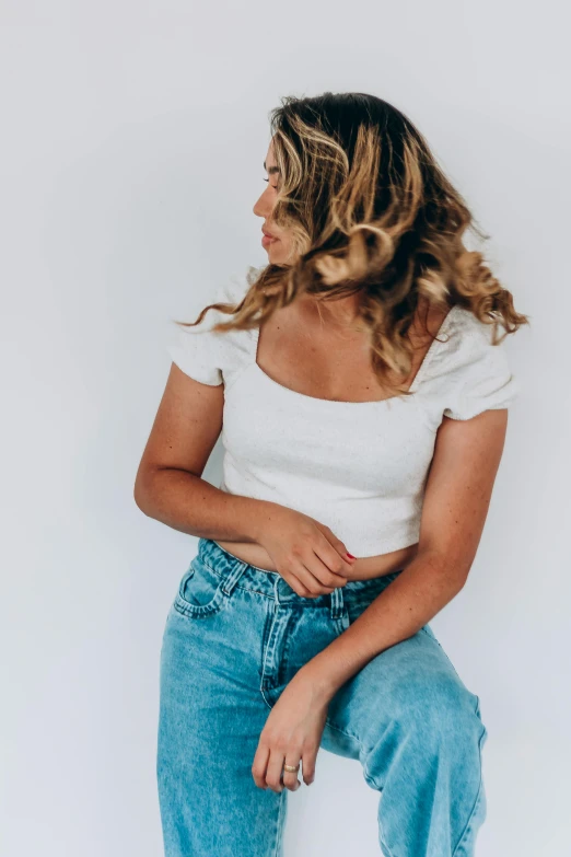 a woman with curly hair wearing blue jeans