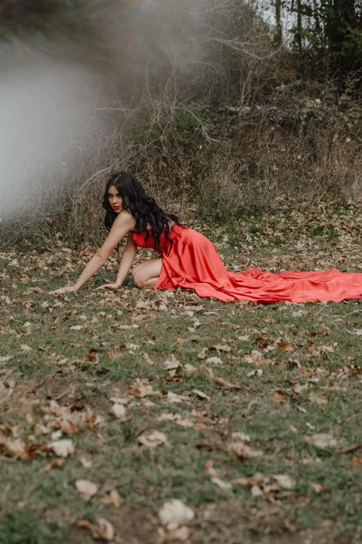 a woman is laying on the grass and blowing soap