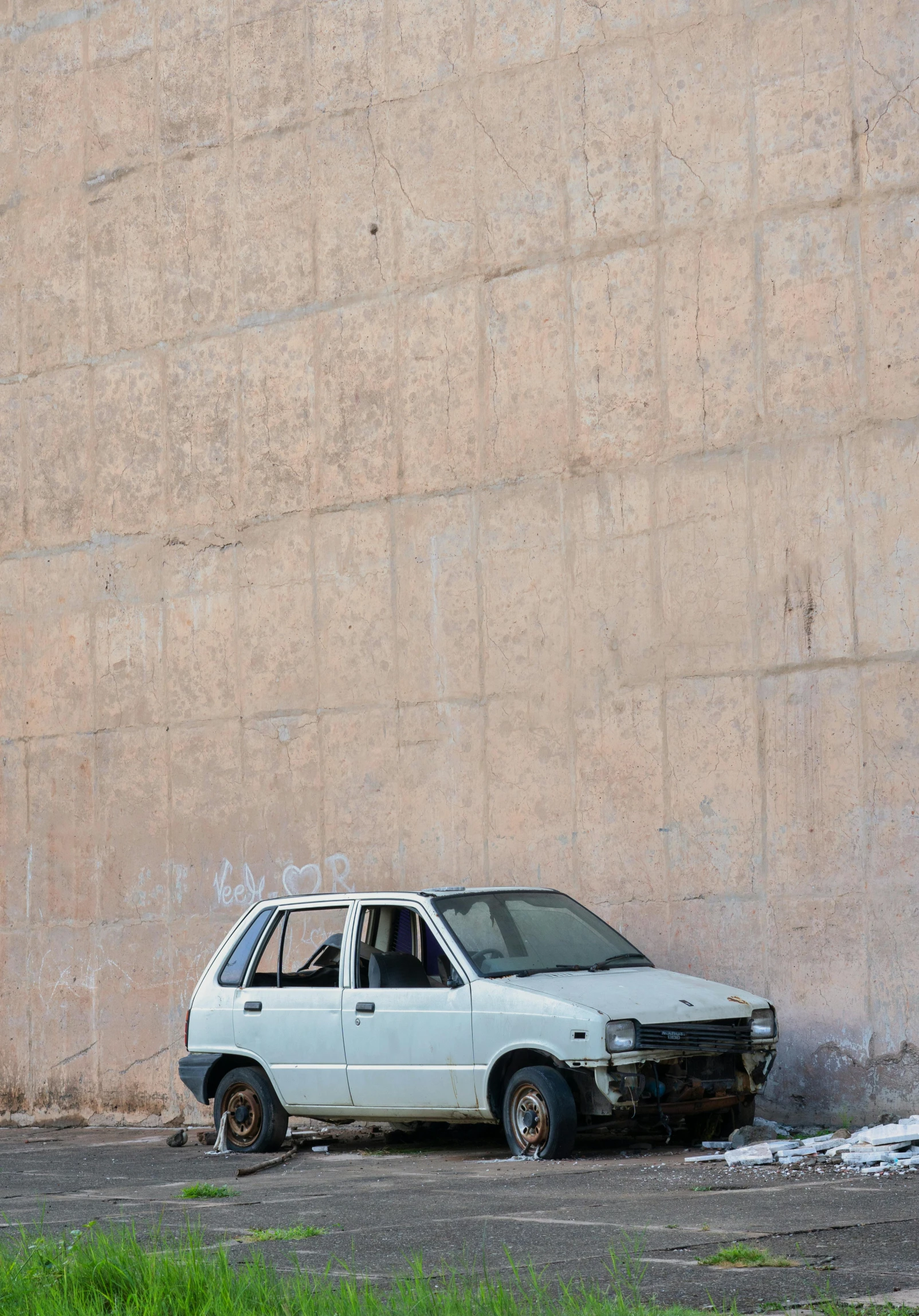 there is an old car that has crashed into the side of a building