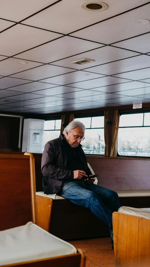 a man sitting in an empty restaurant using a cell phone