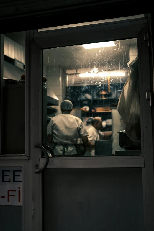 two chefs are cooking in a restaurant on a rainy day