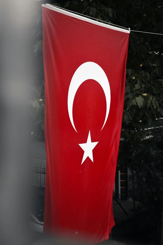 a red and white flag with a crescent and star