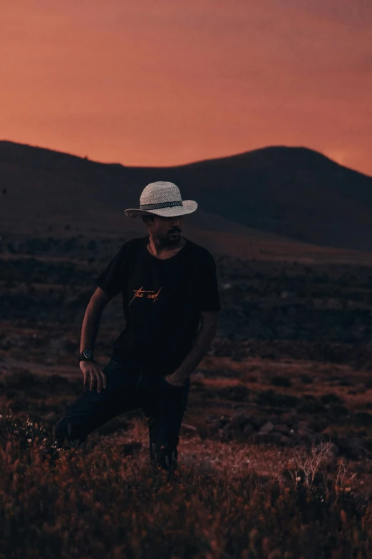 a person wearing a hat is standing in a field