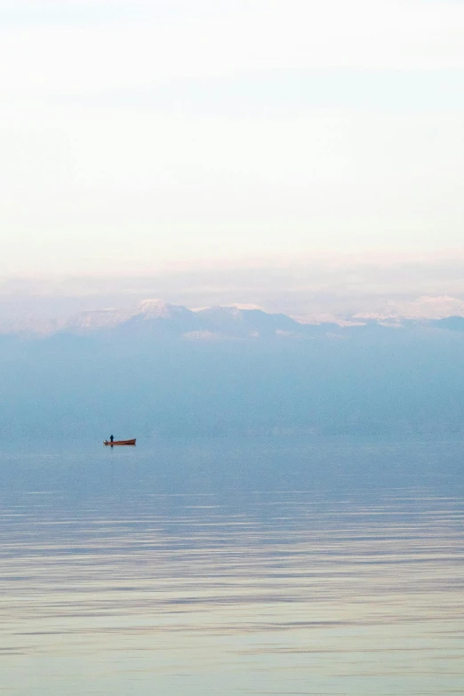 two people in a boat traveling on a calm ocean