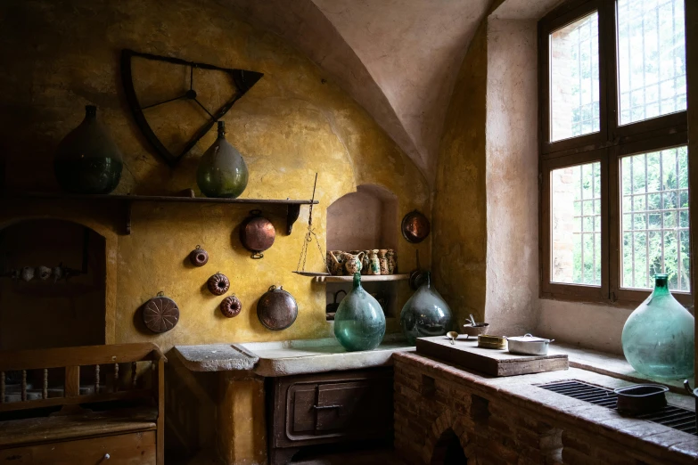 a small kitchen with many colorful vases on the wall