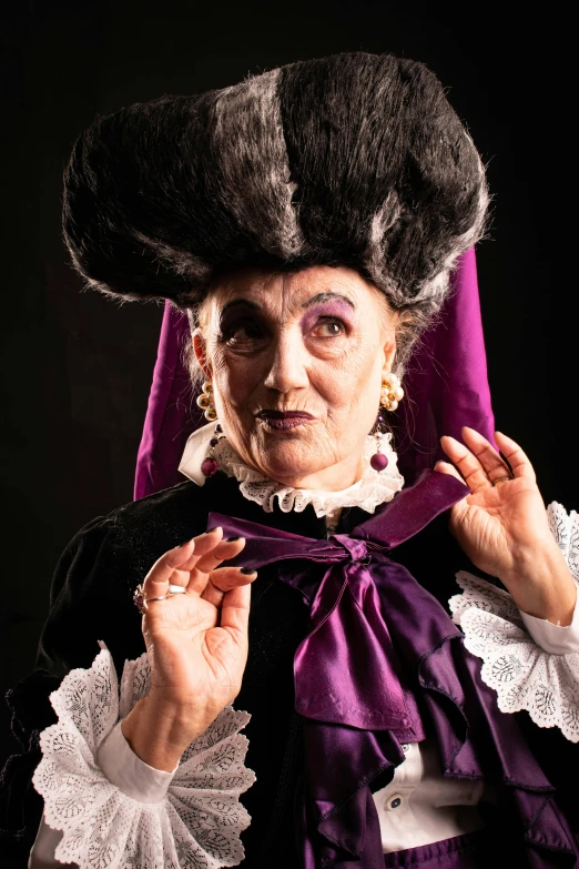 a person in costume and bonnet holds her hand under their ear