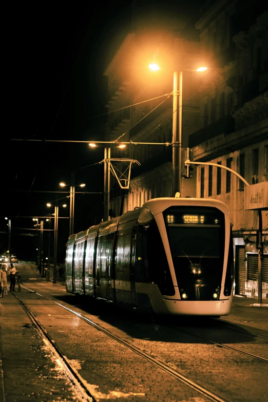 a train is stopped in front of a building at night