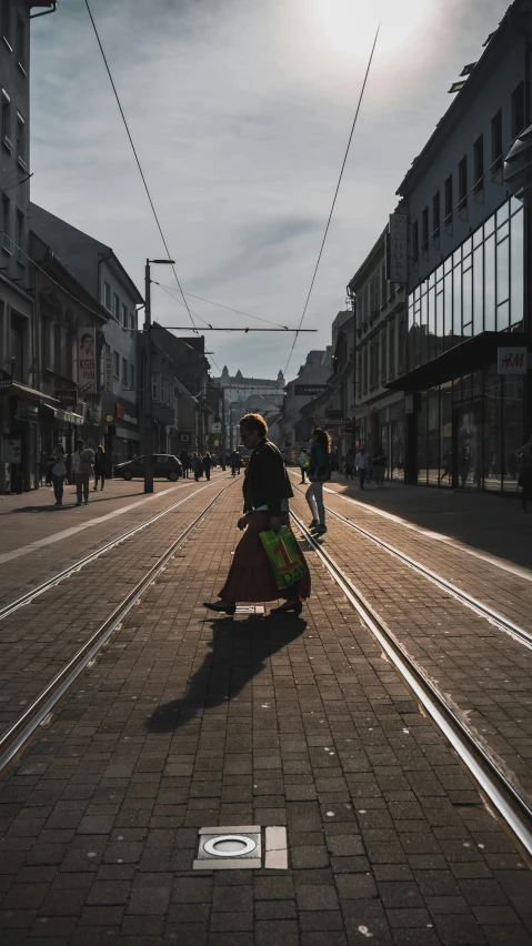 a woman walks in a street holding her umbrella