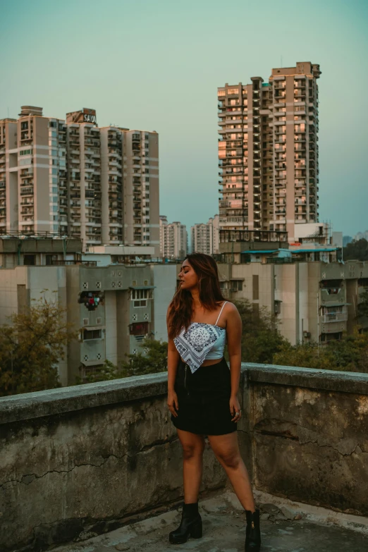 a person standing on a ledge in front of tall buildings