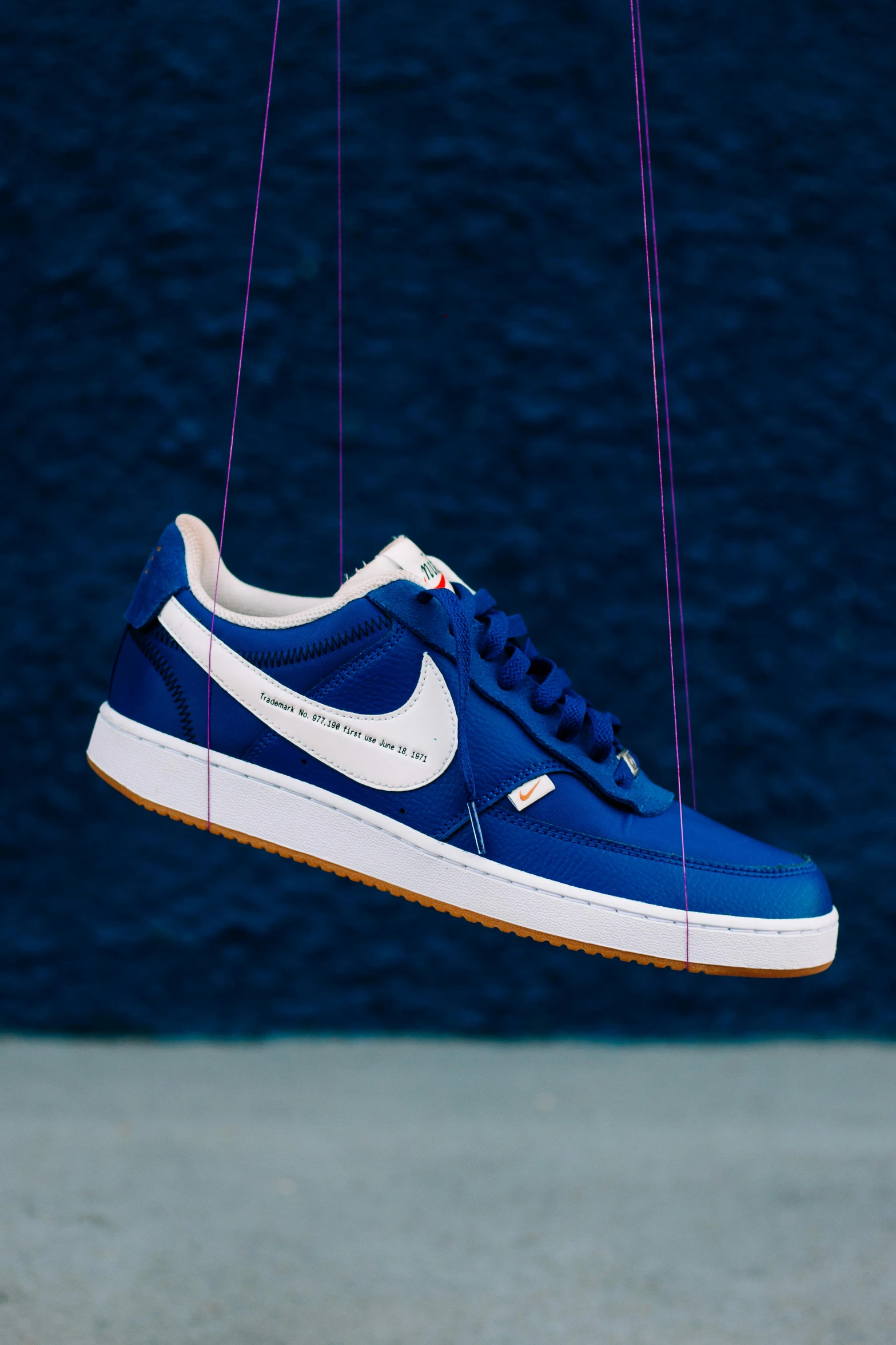 the blue and white nike sneakers hanging from strings