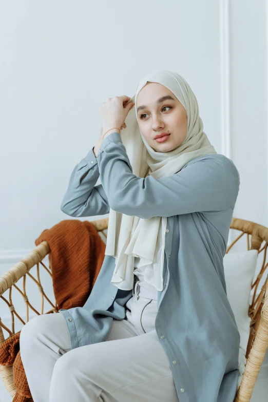 a woman is wearing a grey top with white pants