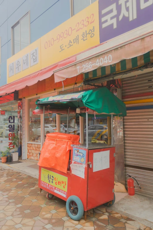 an orange kiosk parked outside of a building