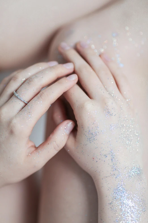 a close up of a woman's hands with sparkle and diamond rings on her thumb