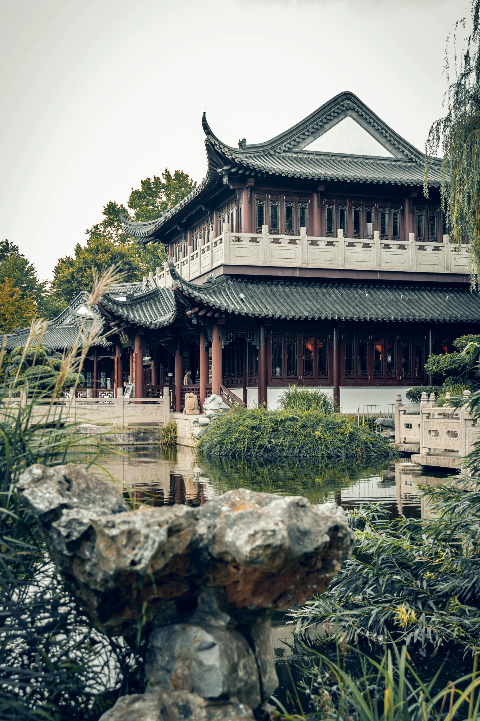 a long building in a park with lots of trees