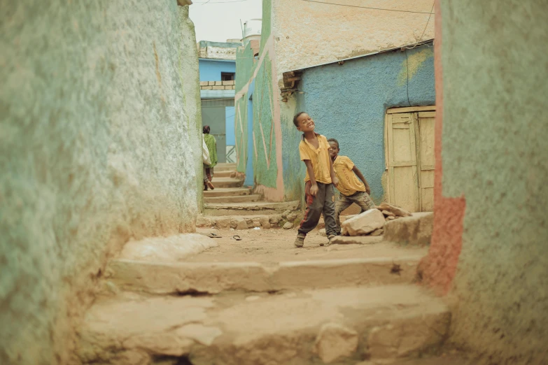 a young child in yellow is walking down a street