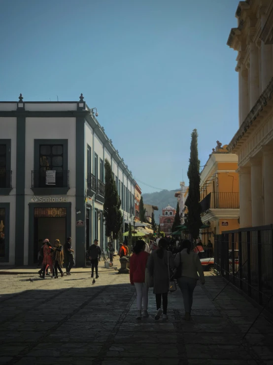 a group of people are walking on a city street