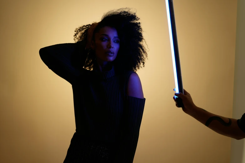 the woman has her hand on a light saber