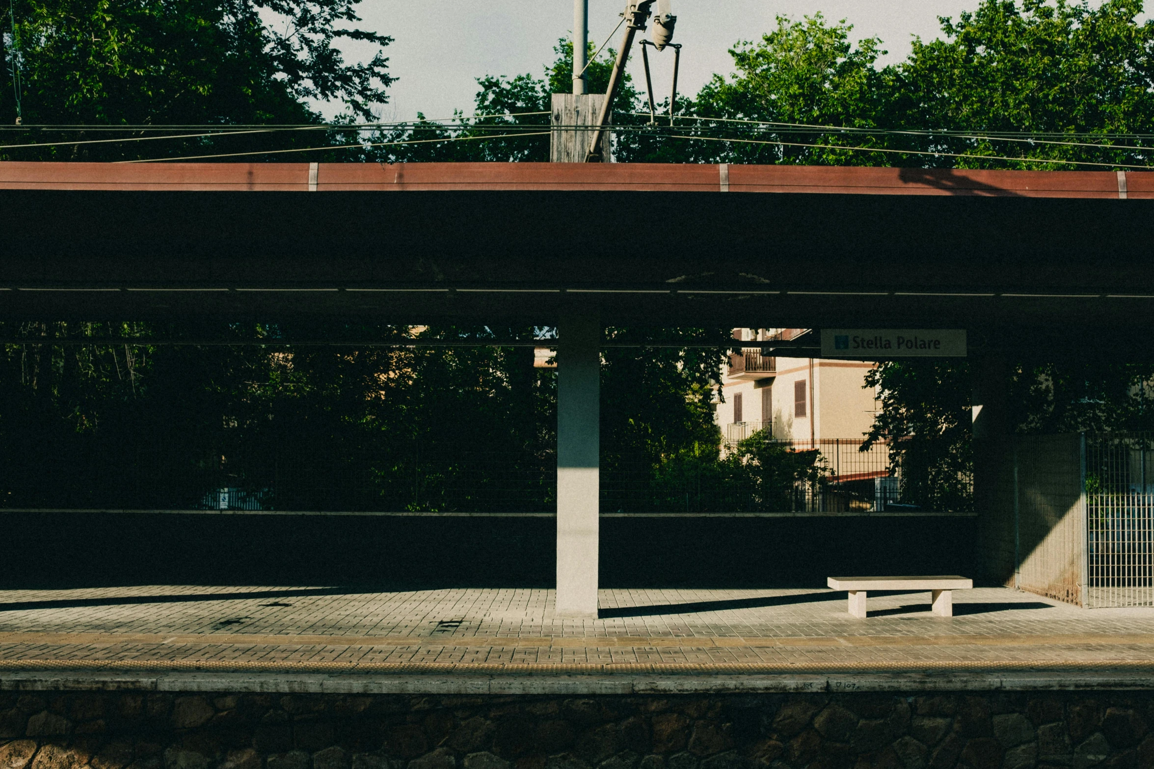 a lone bench is shown underneath an overpass