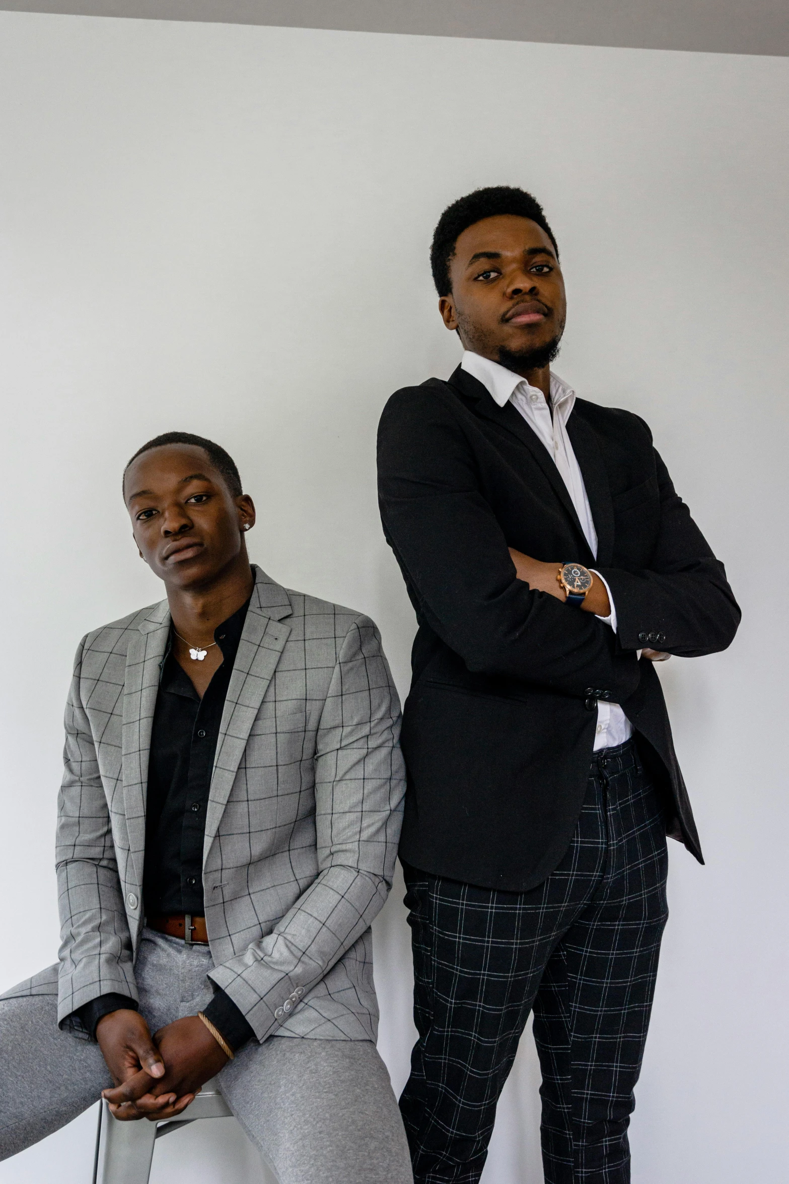 two men pose for a po wearing suits