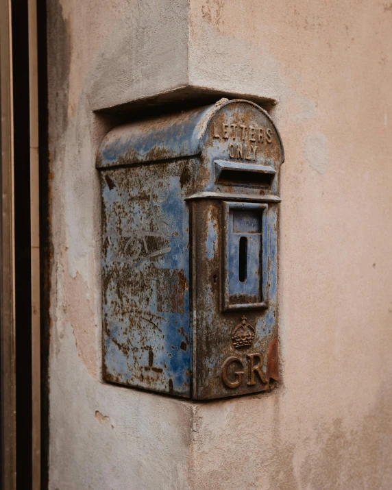 an old mail box is on the wall of an old building