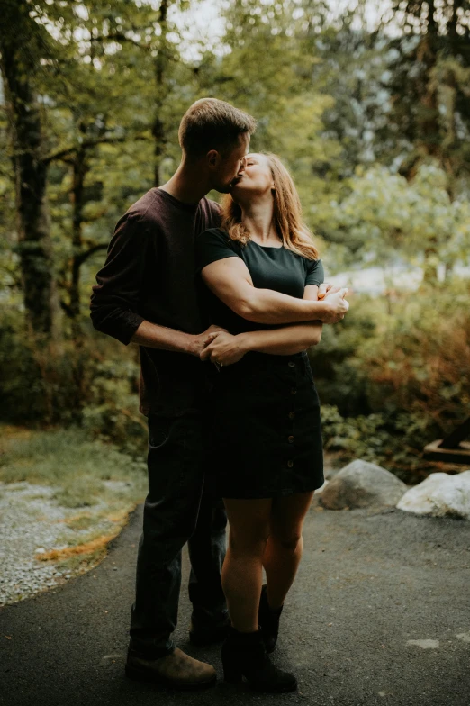 a man and woman are hugging outside