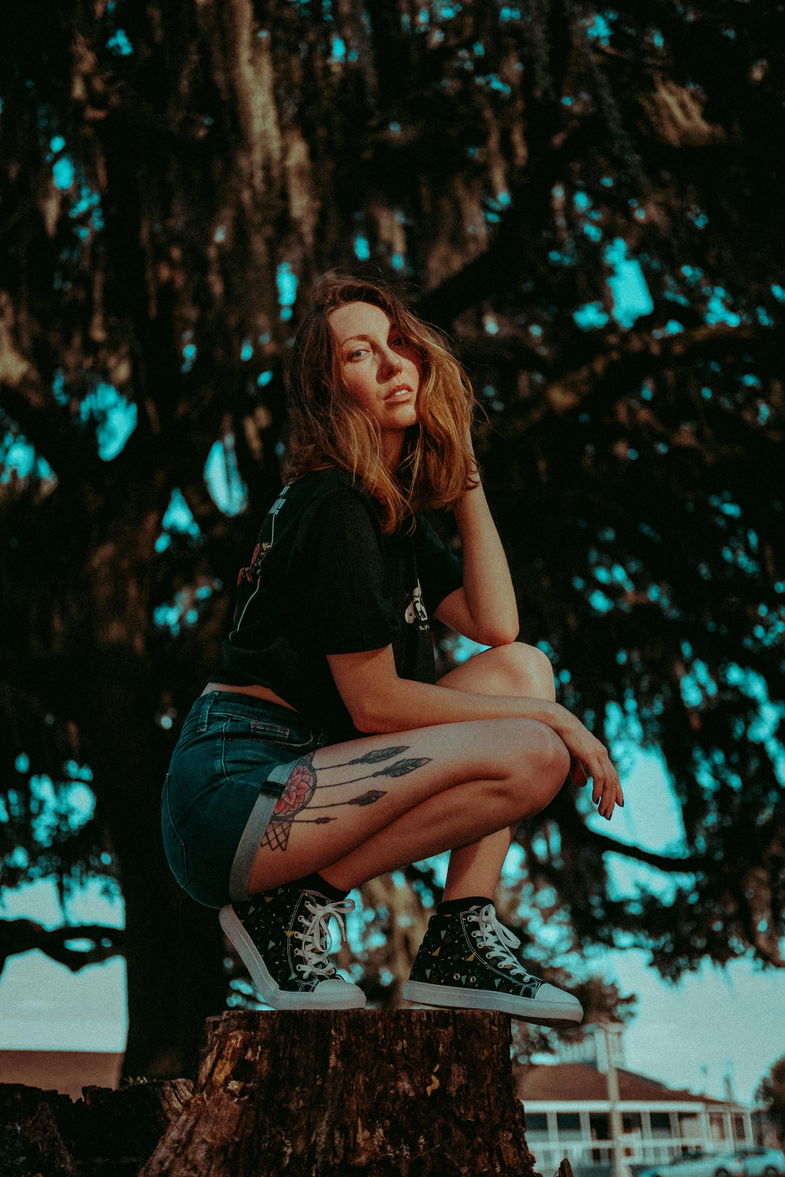 a woman in black shirt and shorts sitting on a bench