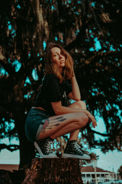 a woman in black shirt and shorts sitting on a bench