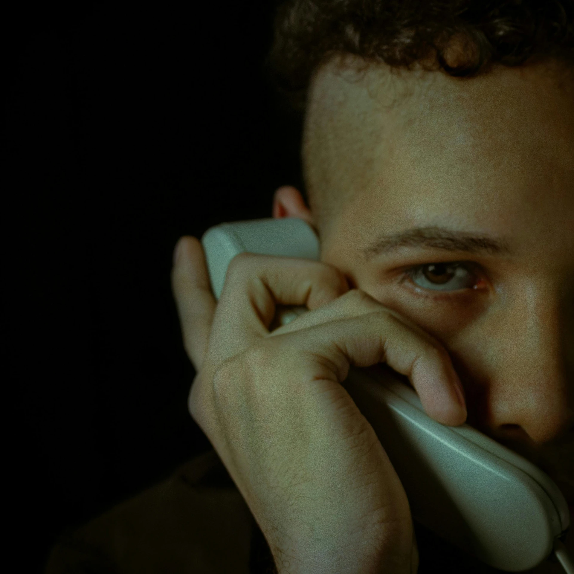 a young man holding a cellphone up to his face