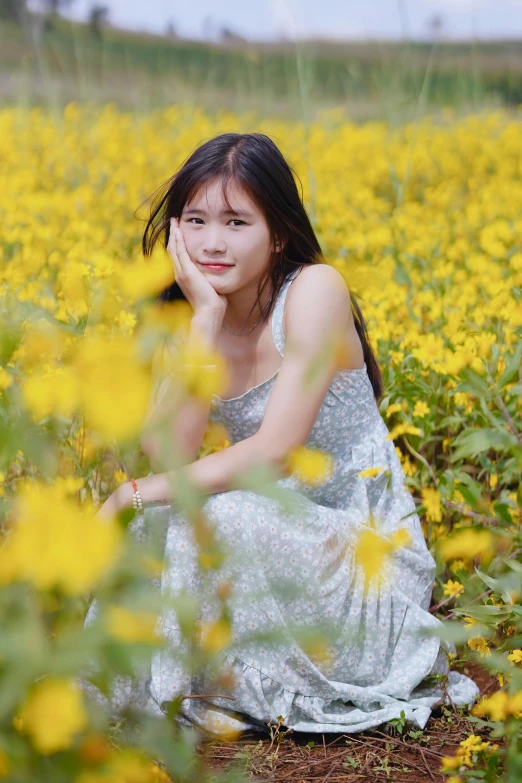 woman in field looking up with yellow flowers