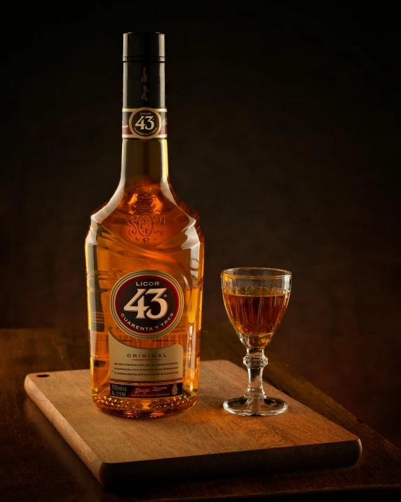 a bottle of alcohol sitting on top of a wooden tray