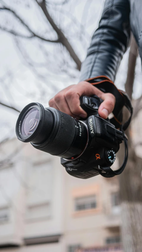 a man holding a camera, taking a po