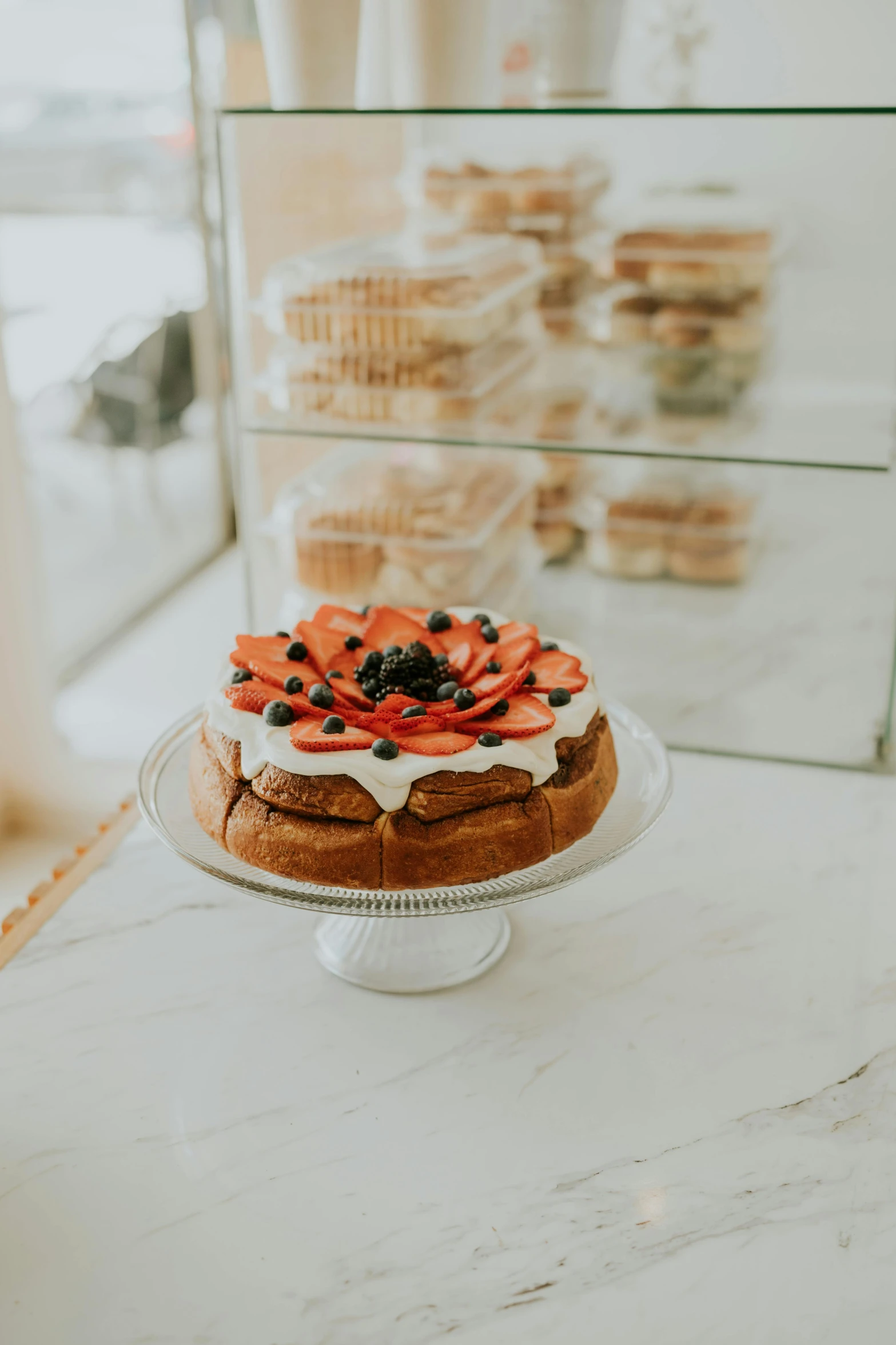 cake with fruit on top displayed in bakery display