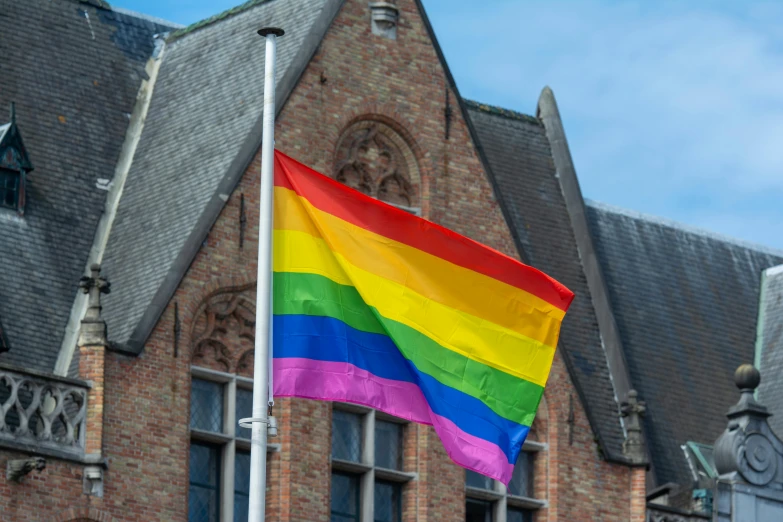 a rainbow flag flies in front of a church