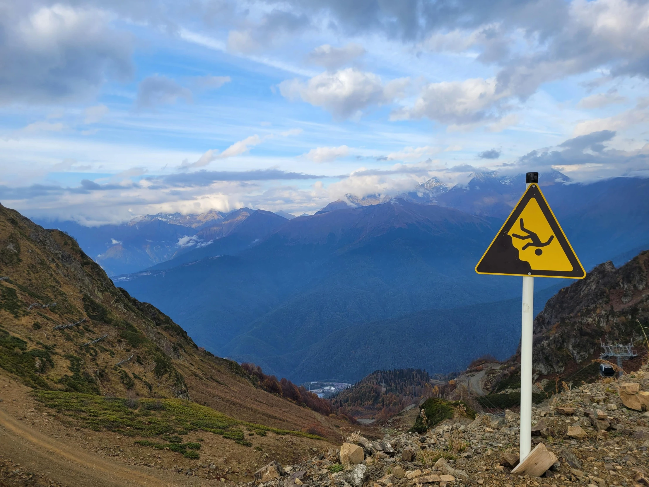 a yellow sign sitting on the side of a rocky hill