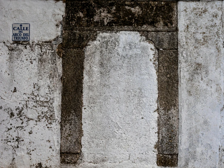 a stone structure is sitting against a concrete wall