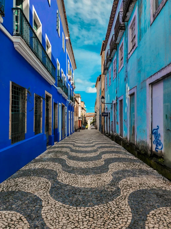 a long street has blue and white buildings