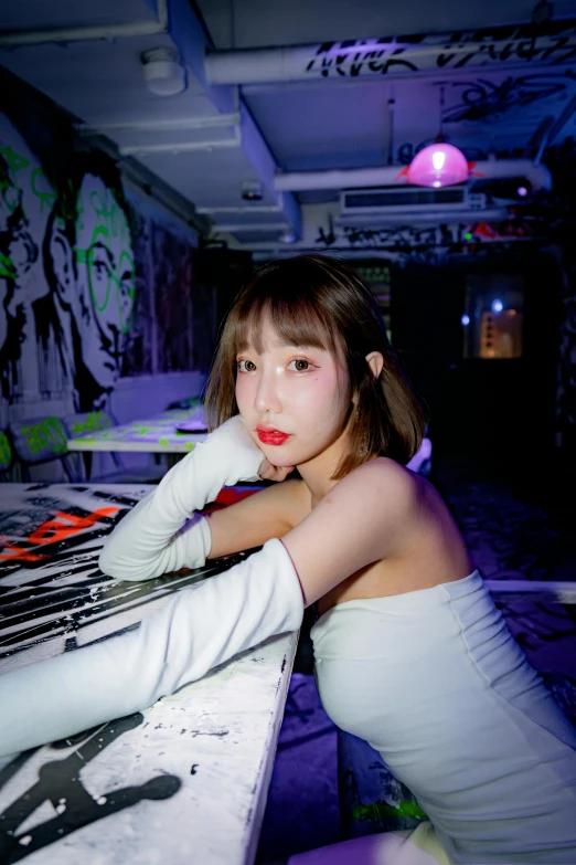 girl in white shirt posing on a bench near graffiti