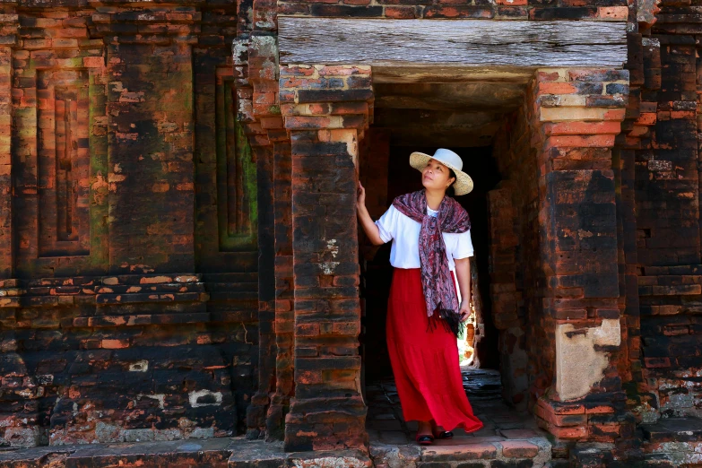 a woman with a hat is standing in an open doorway