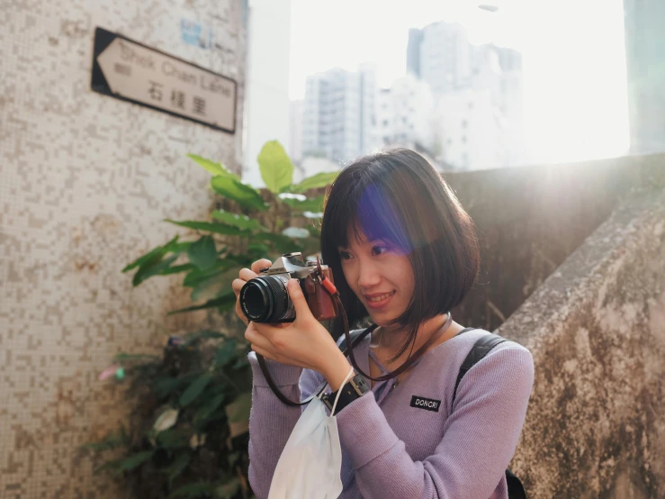 woman taking a picture with her camera at the bottom of a hill