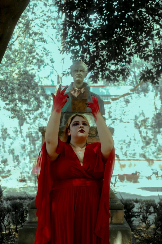 a woman in red in front of a statue