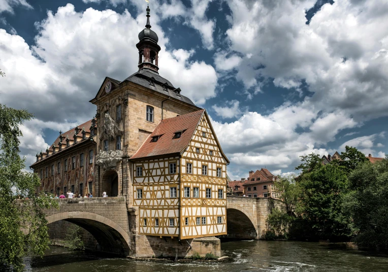 a building near water under cloudy skies with clouds