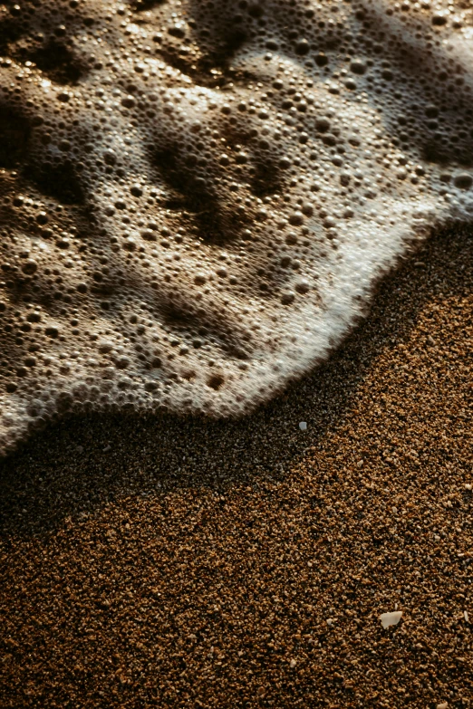 water coming out of the ocean onto beach sand