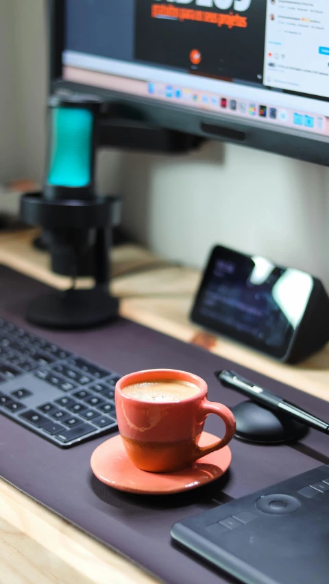 coffee cup on the mouse pad in front of the computer