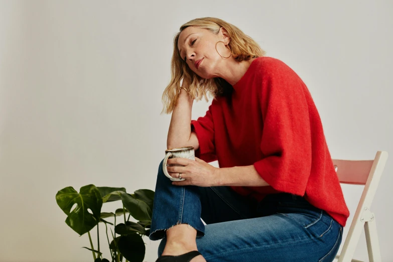 a woman sitting on a chair with her eyes closed