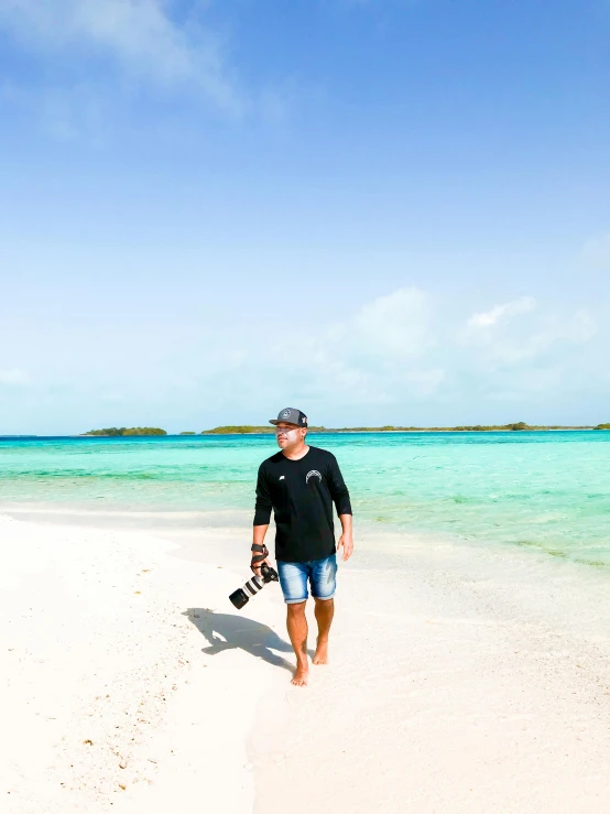 man with long beard walking in the sand on beach