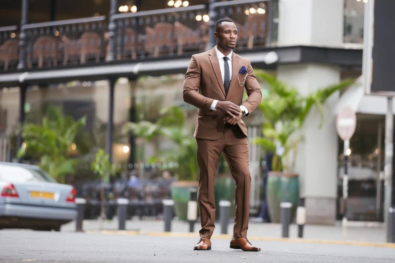 the man in a brown suit is walking on the street