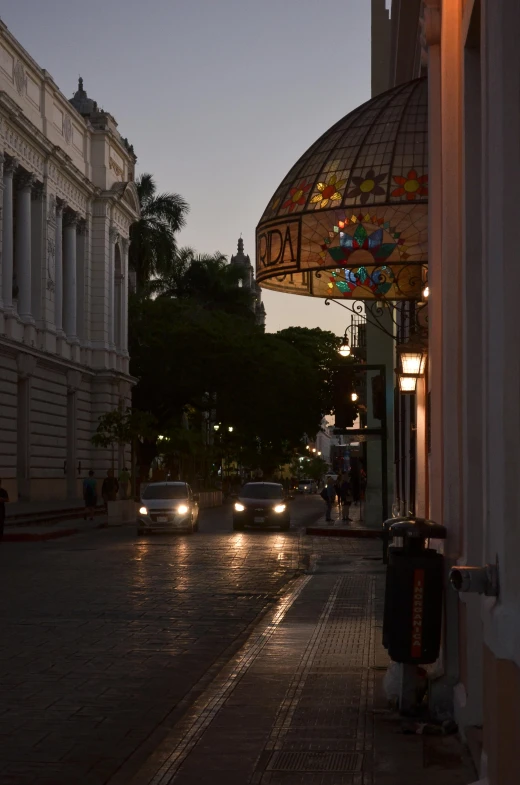 a street at dusk with many parked cars