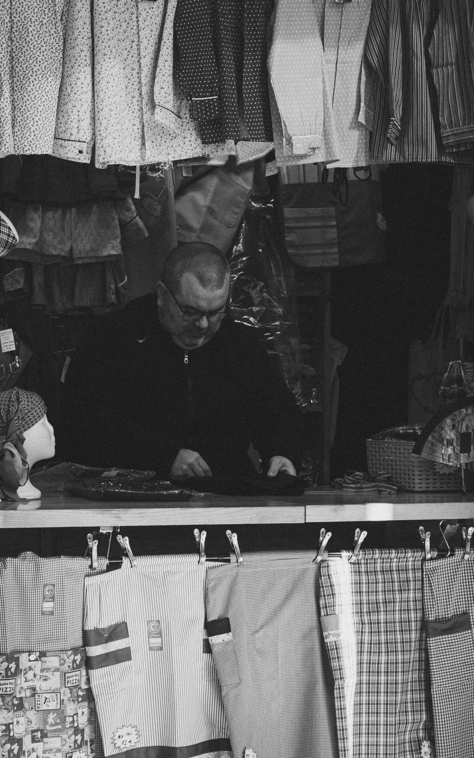 an old man looks at the clothing on display